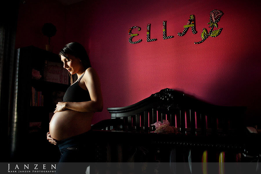 Bare belly maternity portrait in baby nursery