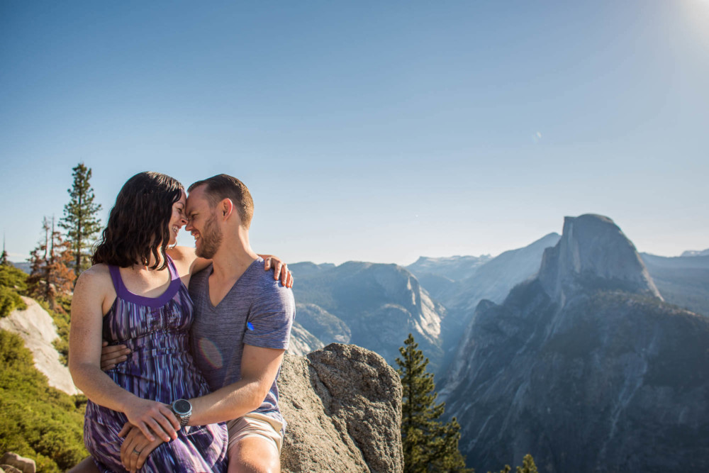 Funny moment between a couple during their engagement session at Glacier Point with Half Dome in the background