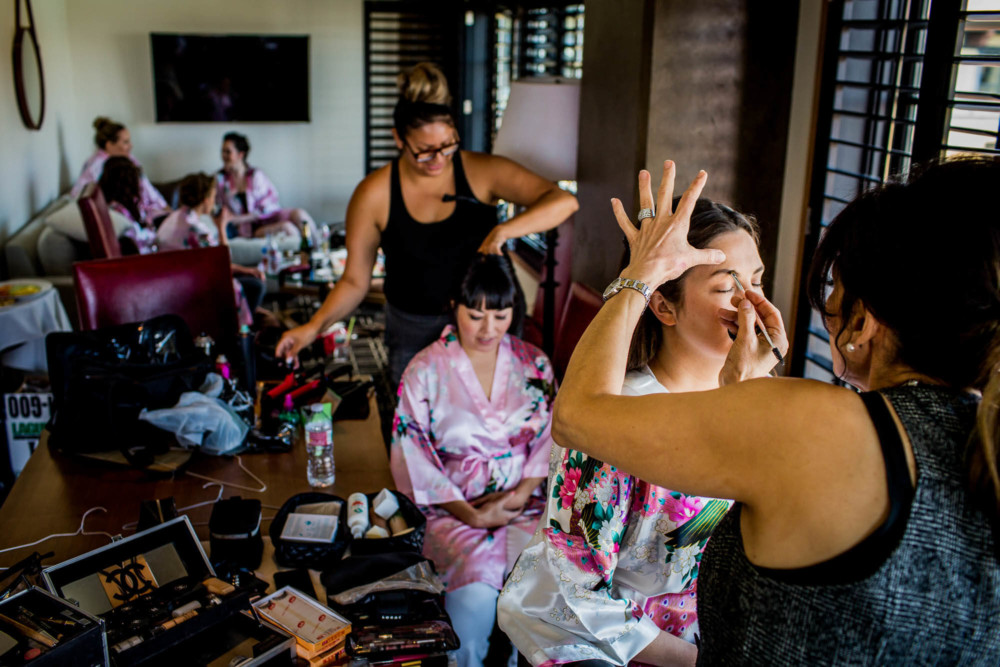 Bride has her makeup done while her bridesmaids are in the background prior to the wedding at the Hotel Valencia on Santana Row in San Jose, CA