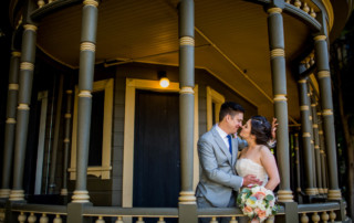 Portrait of a bride and groom on a porch at the Winchester Mystery House in San Jose, CA