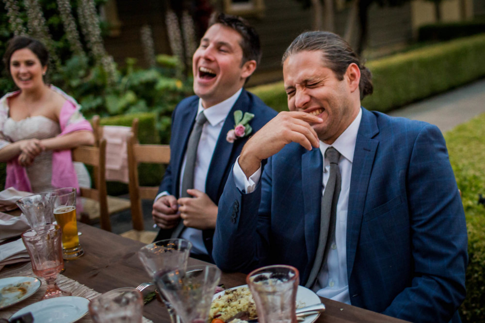 Groomsmen laugh at a joke told by a friend at a wedding reception at The Winchester Mystery House in San Jose, CA