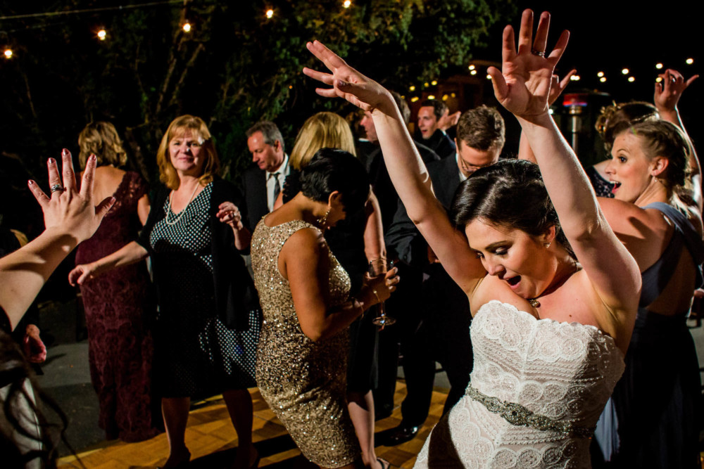 The bride and group of wedding guests dancing at a reception at the Winchester Mystery House in San Jose, CA
