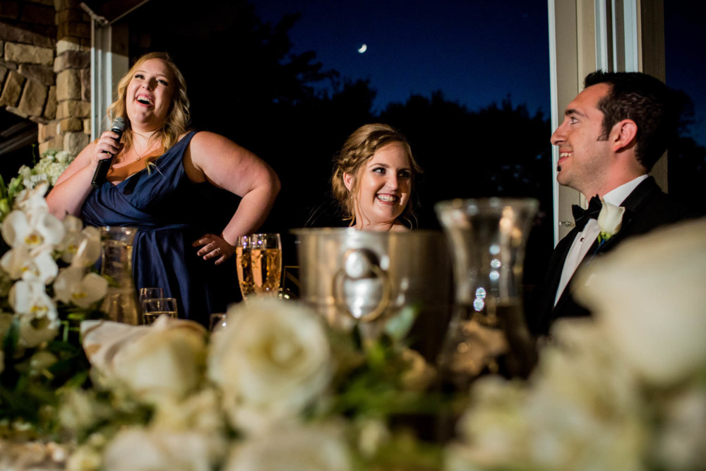 Bride and groom react, laughing at the Maid of Honor's speech at their wedding reception at Wolf Lakes Park