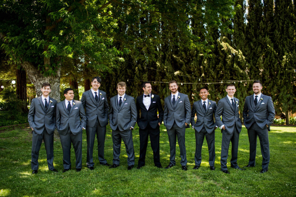 Groom and groomsmen laughing in a portrait at Wolf Lakes Park in Fresno, CA