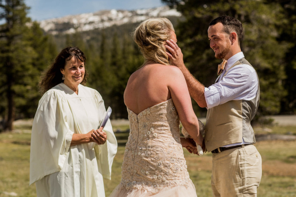 A Groom's tenderly touching his bride's cheek during their elopement in Tuolumne Meadows in Yosemite National Park