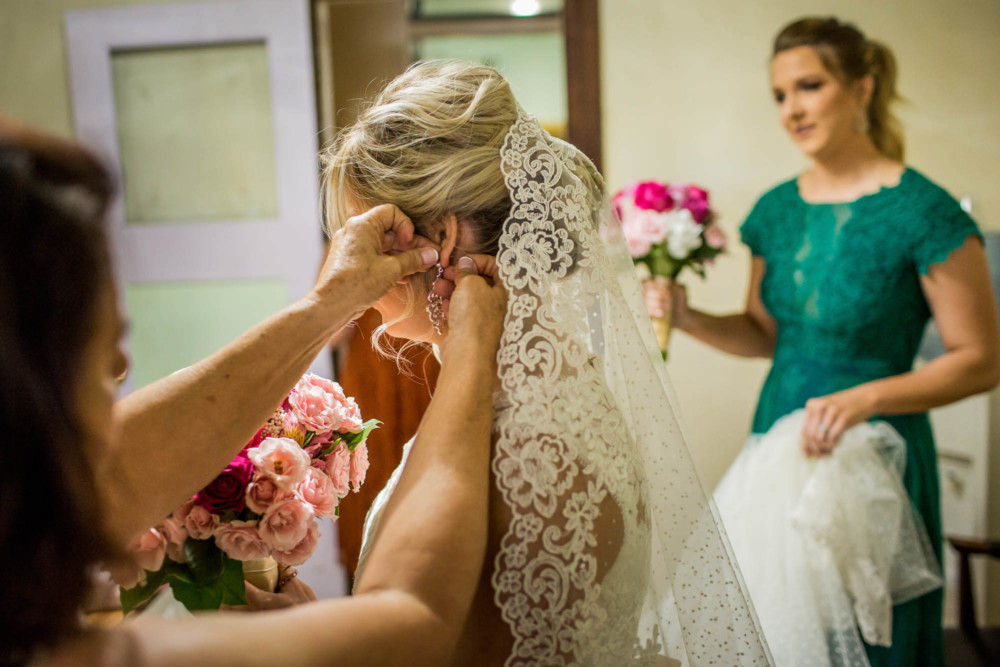 Putting on the bride's earrings before her wedding