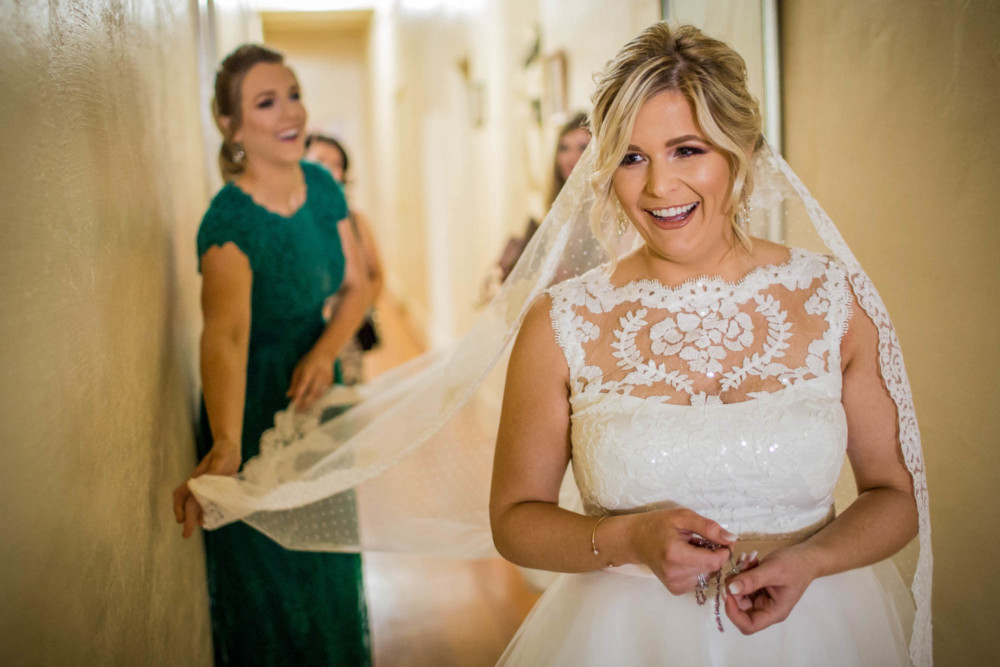Maid of honor spreads out the veil before the bride walks down the aisle