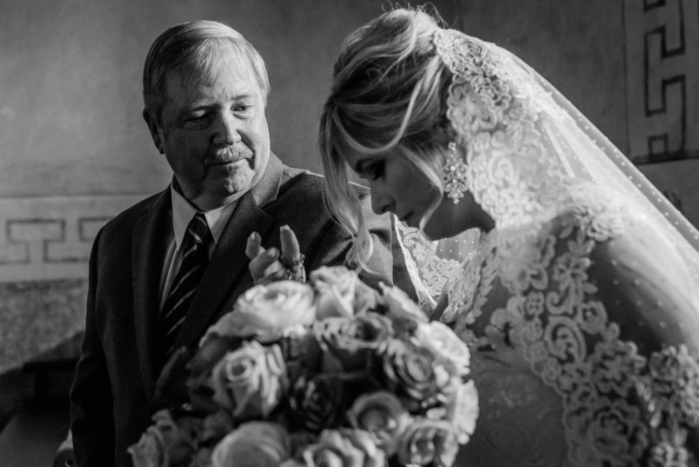 Father of the bride looks at his daughter before walking her down the aisle