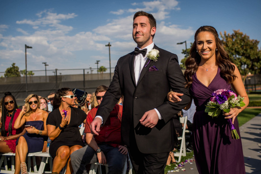 Groomsman and Bridesmaid walk down the aisle at a wedding at Copper River Country Club