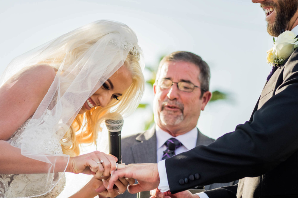 Bride struggles to place the ring on the grooms finger at Copper River Country Club