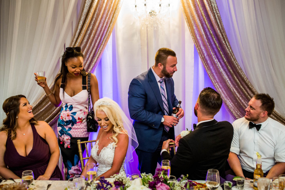 Wedding guests react and laugh during a reception at Copper River Country Club