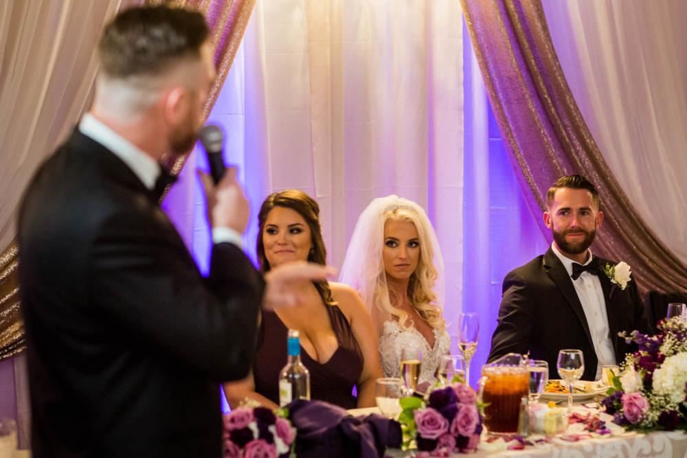 Bride and groom react to heartfelt speech by groomsman at their wedding reception at Copper River Country Club