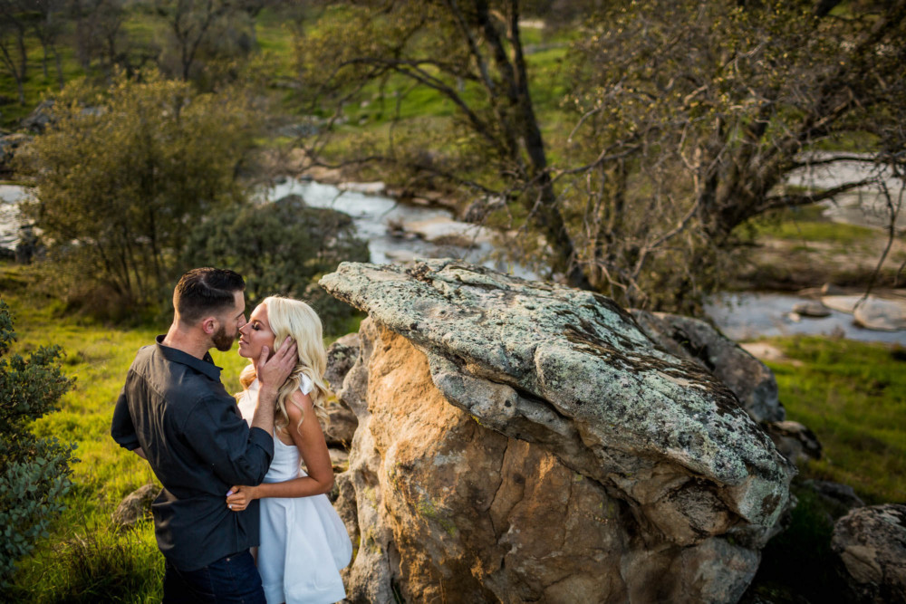 Man and woman kissing during an engagement session in the foothills