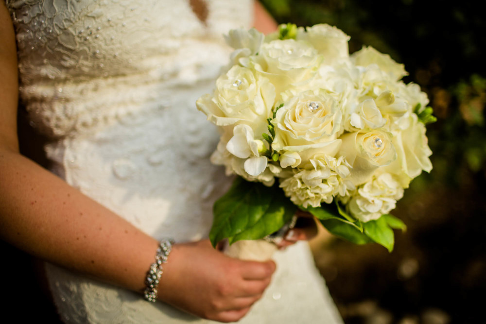 Detail of the bride's white rose bouquet and bracelet
