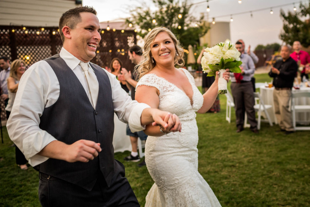 Bride and groom joyfully enter their reception at Moravia Wines