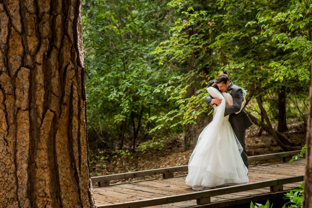 Bride and groom embrace during their first look at the Majestic Yosemite Hotel
