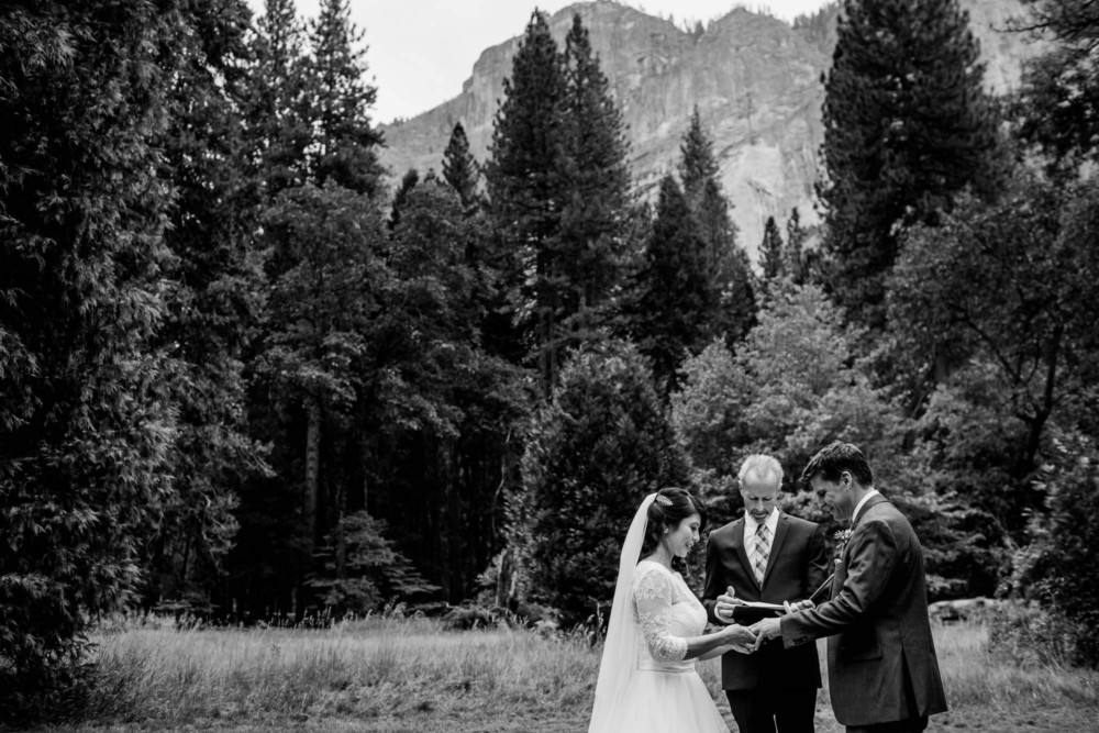 Bride and groom exchange rings during their ceremony at The Majestic Yosemite Hotel
