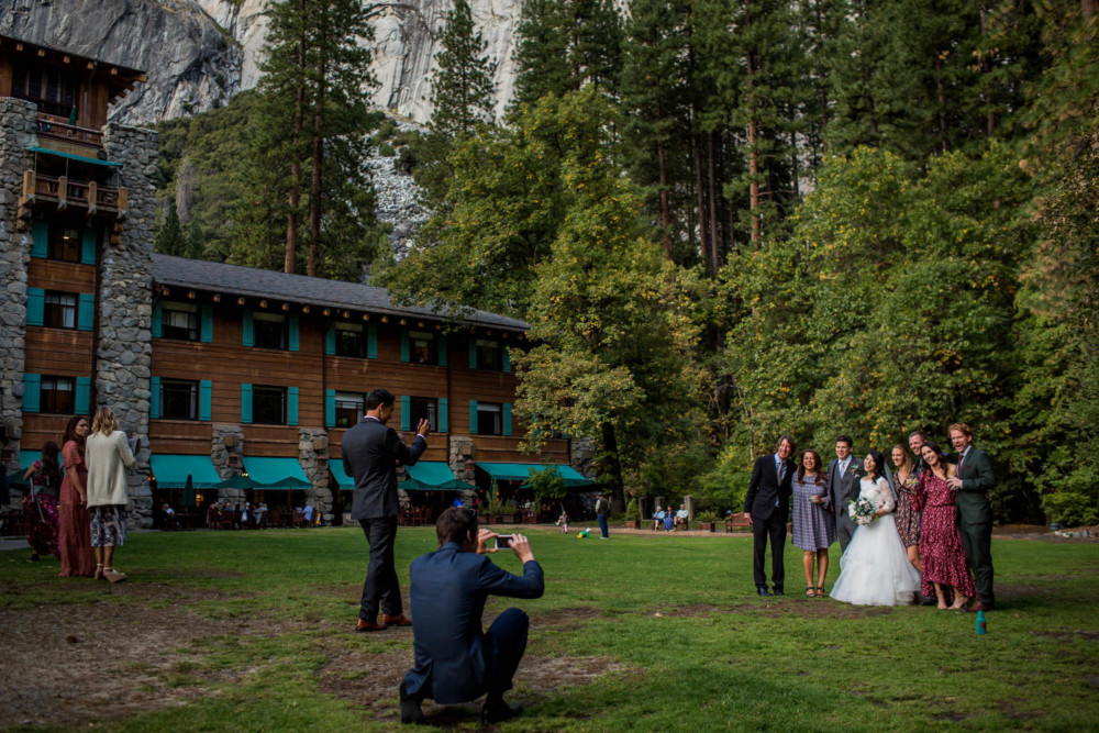 Scene from the Ahwahnee hotel while bride and friends pose for guests on the lawn