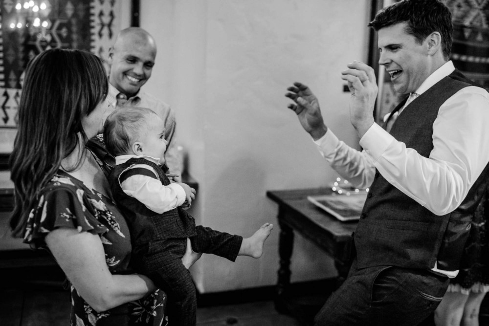 Grom plays with baby during the wedding reception