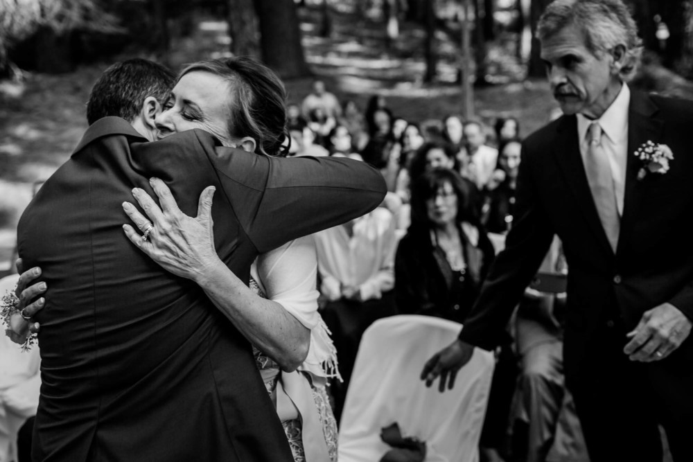 Groom hugs is mother before she sits during the wedding ceremony