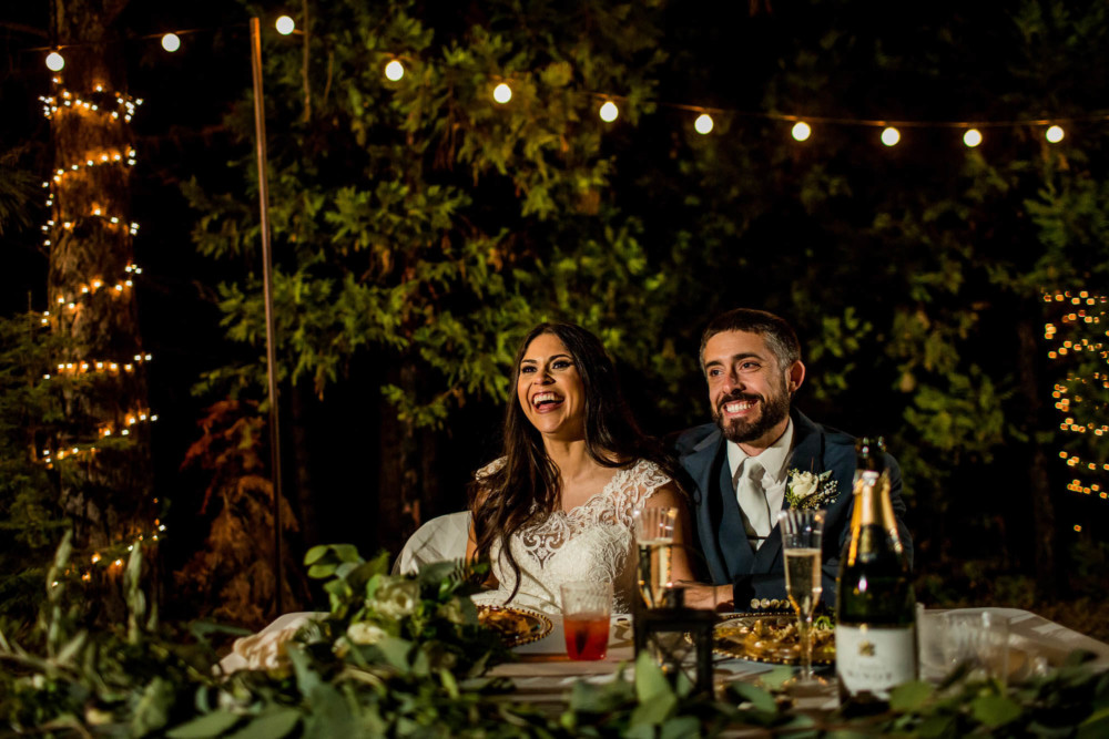 Bride and groom react with laughter to the best man's speech