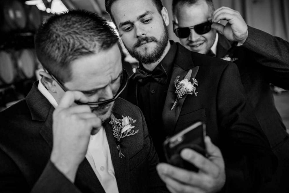 Groom and groomsmen checking out a phone