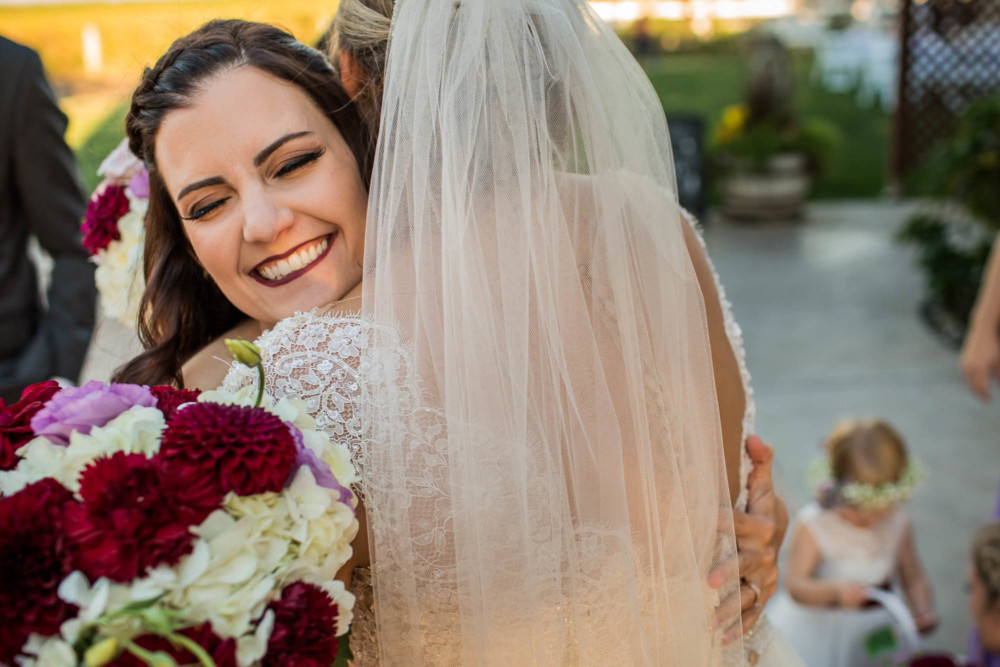 Bridesmaid gives a congratulatory hug to the bride after the wedding ceremony