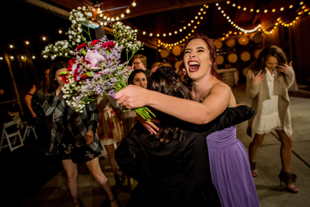 Bridesmaid cheers in triumph after catching the bouquet