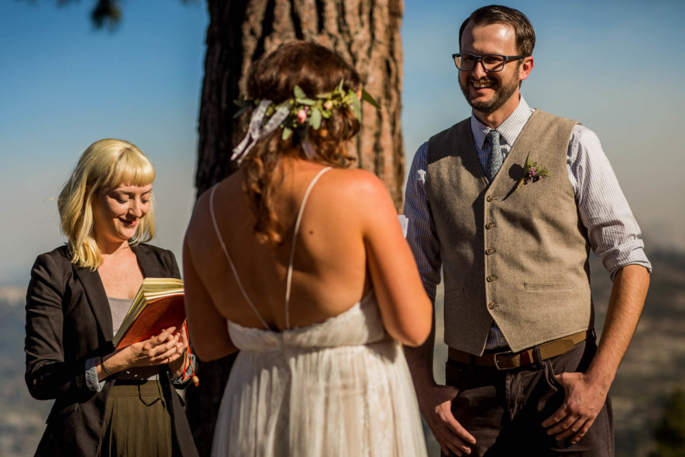 Groom smiles as his bride reads her vows during the wedding