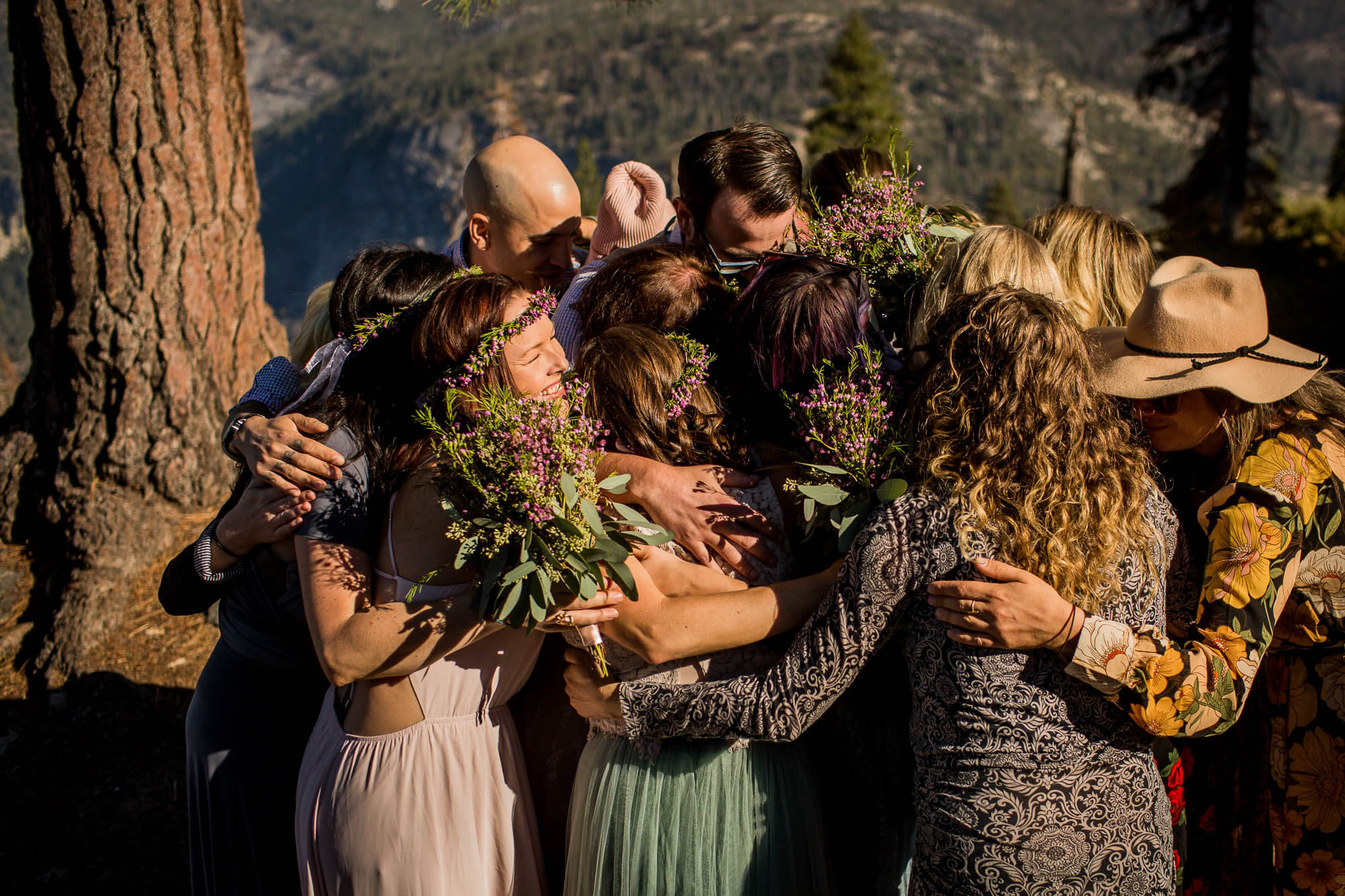 Bride and Groom crushed in a group hug after their wedding ceremony