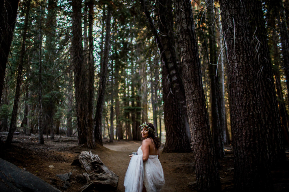 Bride looks back as she hikes down the trail to Taft Point