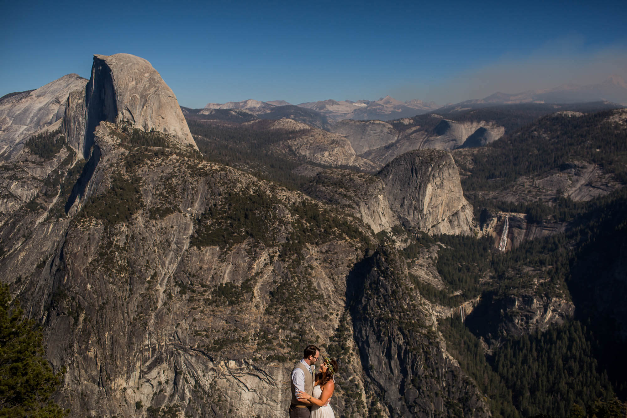 Portrait of bride and groom at Glacier Point where they seem to float over the valley across from Half Dome and Nevada Falls
