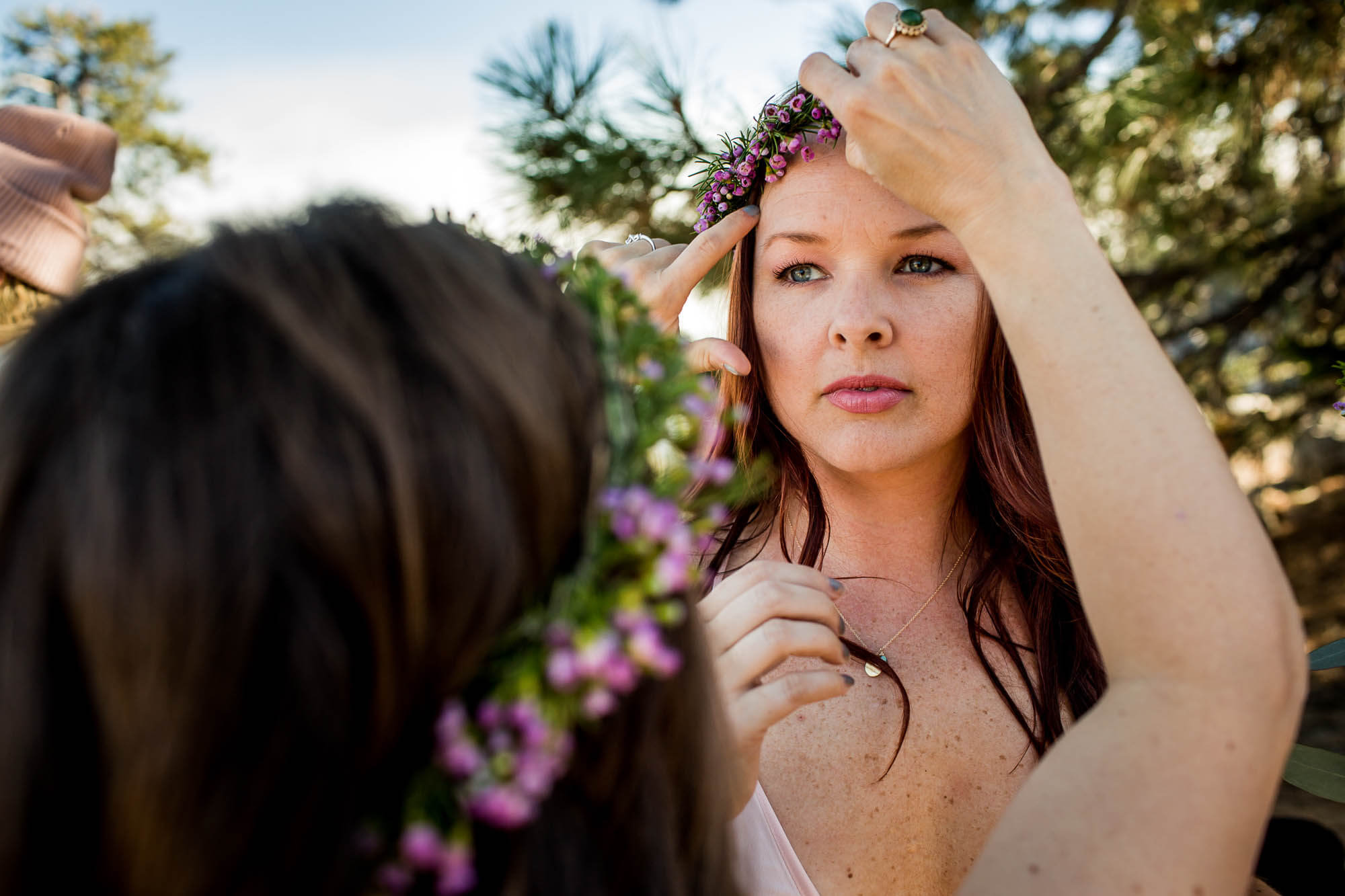 Bridesmaid adjusts another bridesmaid's flower crown