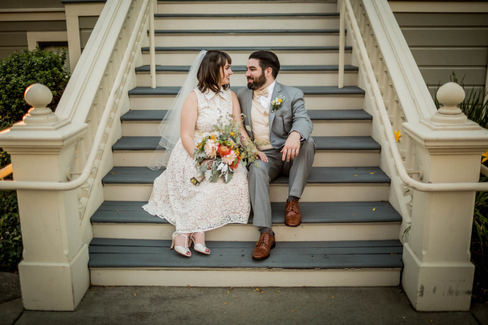 Portrait of a bride and groom sitting on a Victorian staircase