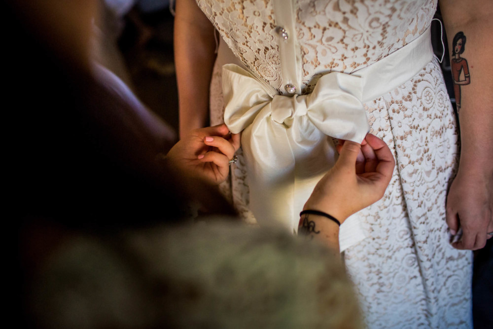 Bridesmaid ties bride's bow