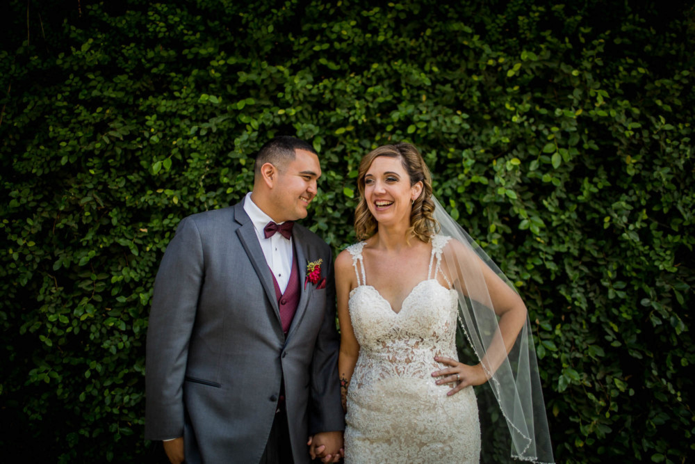 Wedding portrait of bride and groom against an ivy wall
