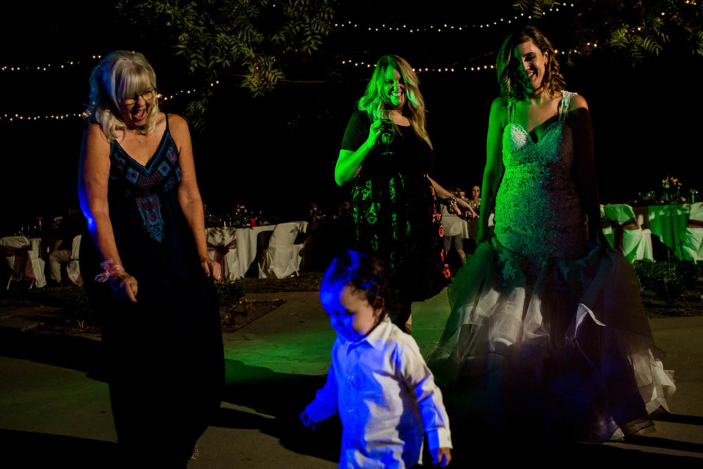 Baby dancing in the colorful DJ lights during the wedding reception