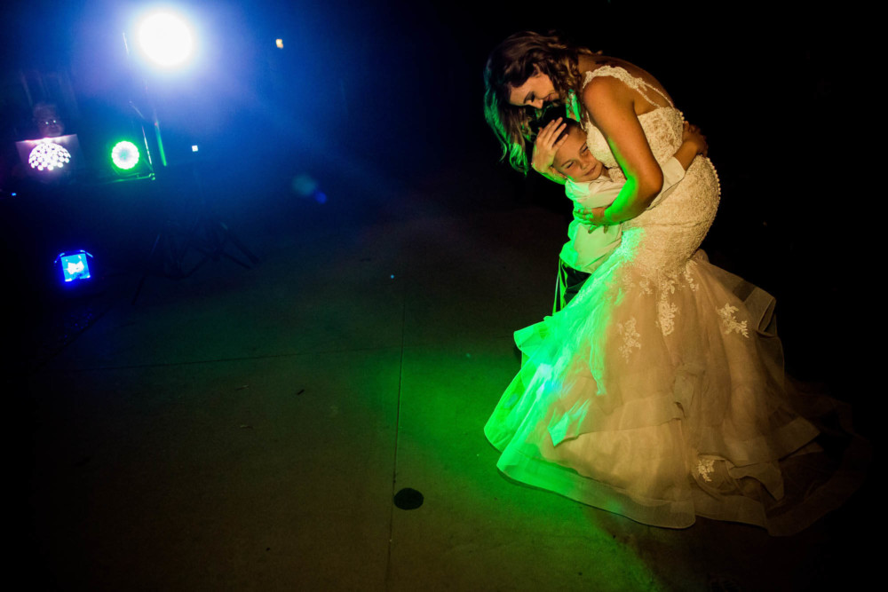 Guests dancing in the colorful DJ lights during the wedding reception