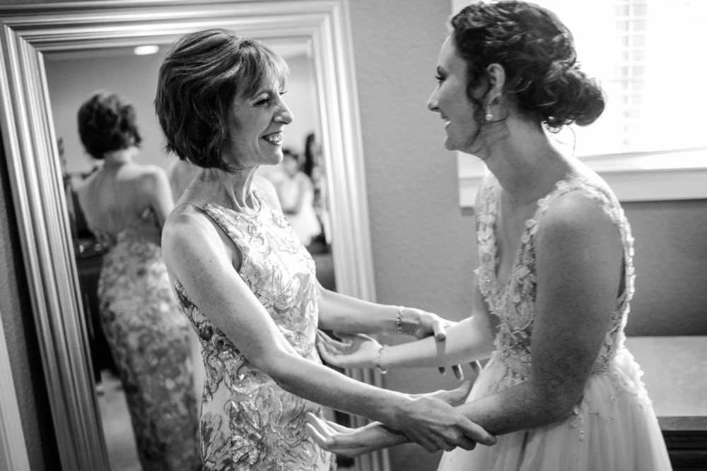Bride and mother of the groom share a moment and a laugh