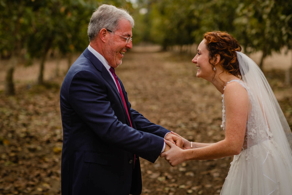 Bride and her father laugh during their first look