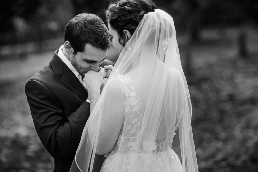 Groom kisses the bride's hand during their first look