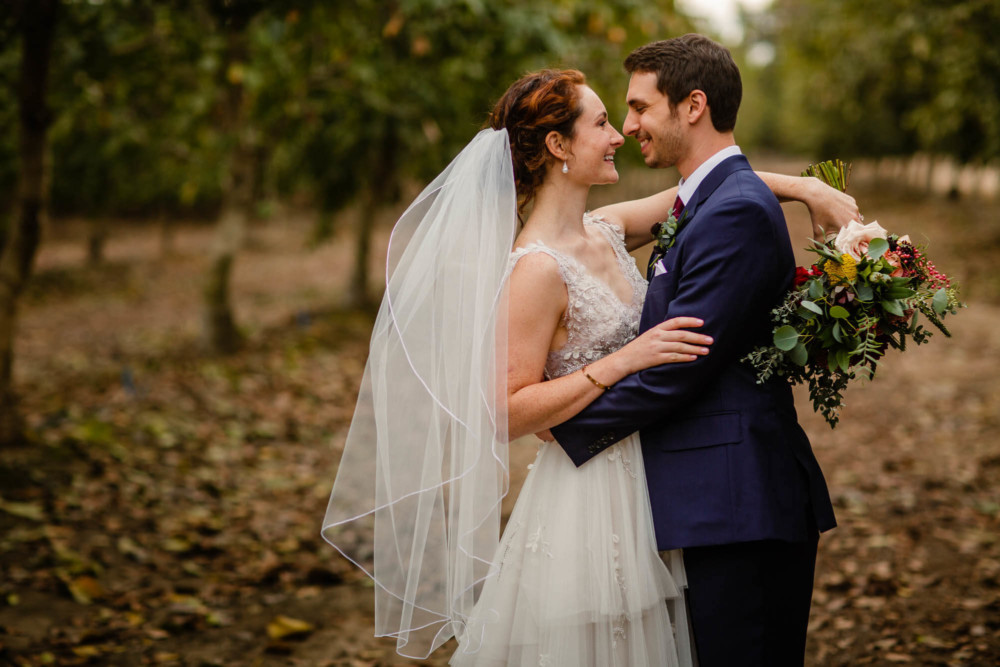 Portrait of a bride and groom in an orchard