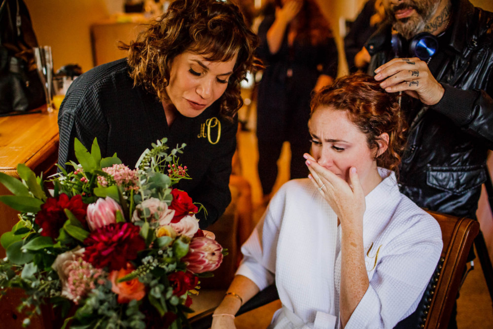 Bride has an emotional moment when mother shows her the charms on her bouquet