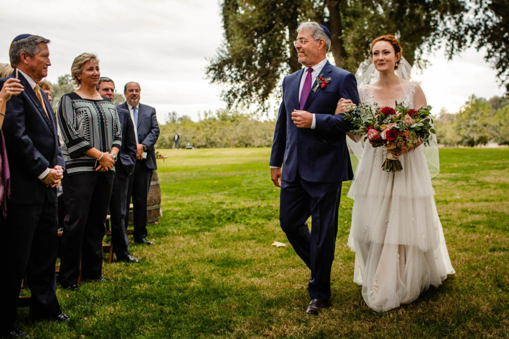 Father walks his daughter down the aisle at her wedding