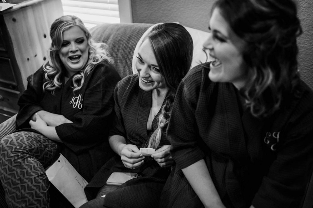 Bridesmaids laugh while getting ready