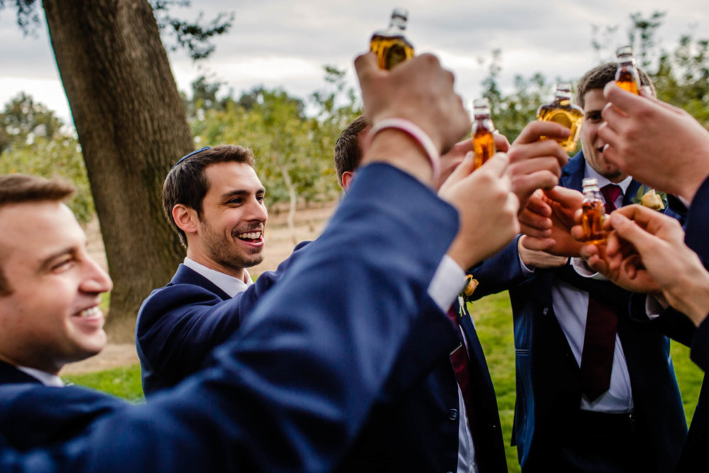 Groom and groomsmen toast with tiny bottles of Crown Royale