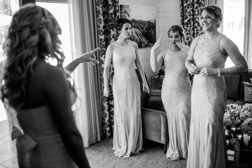 Bridesmaids react upon seeing the bride in her dress for the first time
