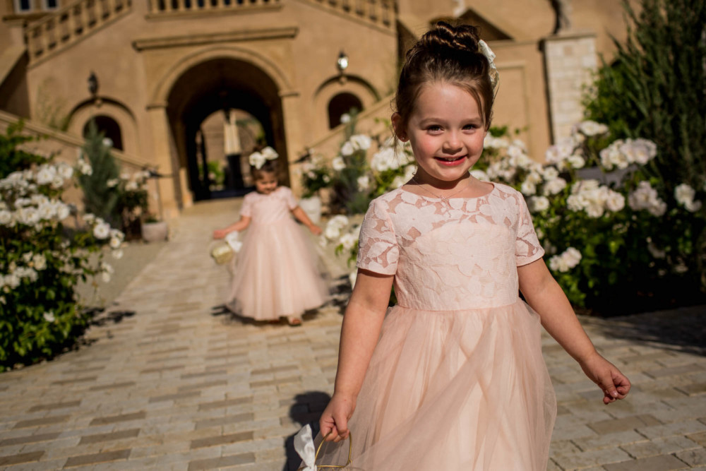 Flower Girls enter the courtyard through an arched tunnel during the processional