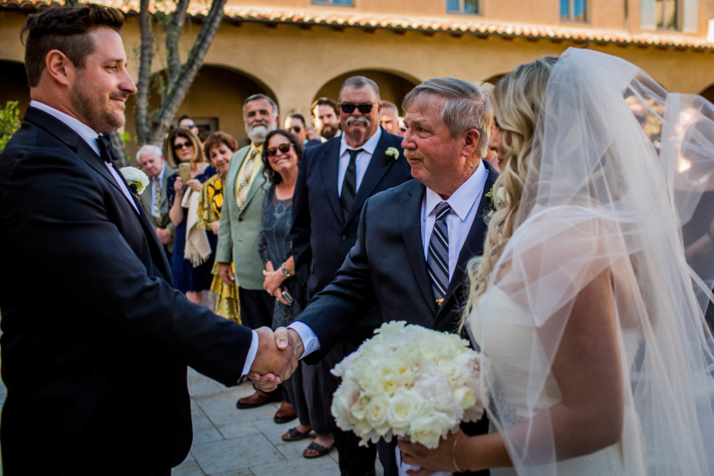 Father of the bride shakes the groom's hand at the start of the wedding ceremony