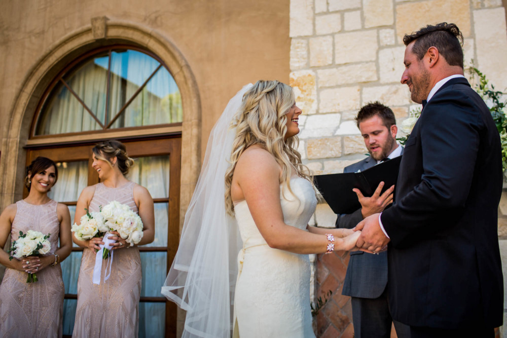 Bride, groom and bridesmaids laugh during the wedding ceremony